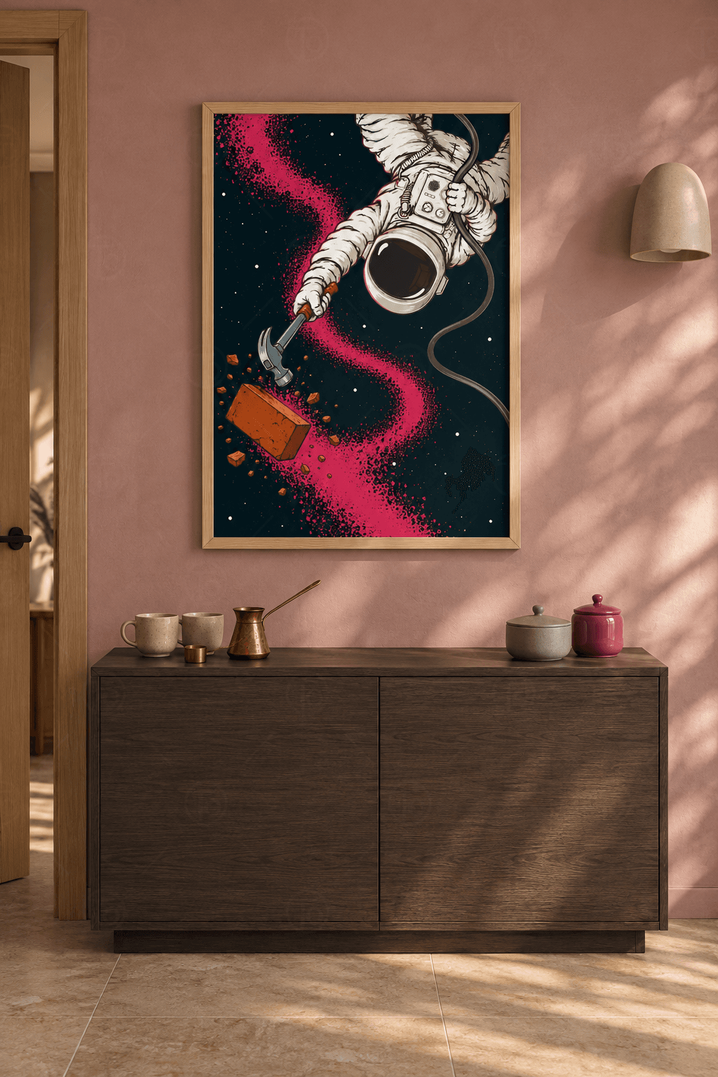 Ahşap çerçeveli astronot tablosu — siyah uzayda çekiç sallayan beyaz giysili astronot, dağılan tuğla ve pembe yıldız tozu