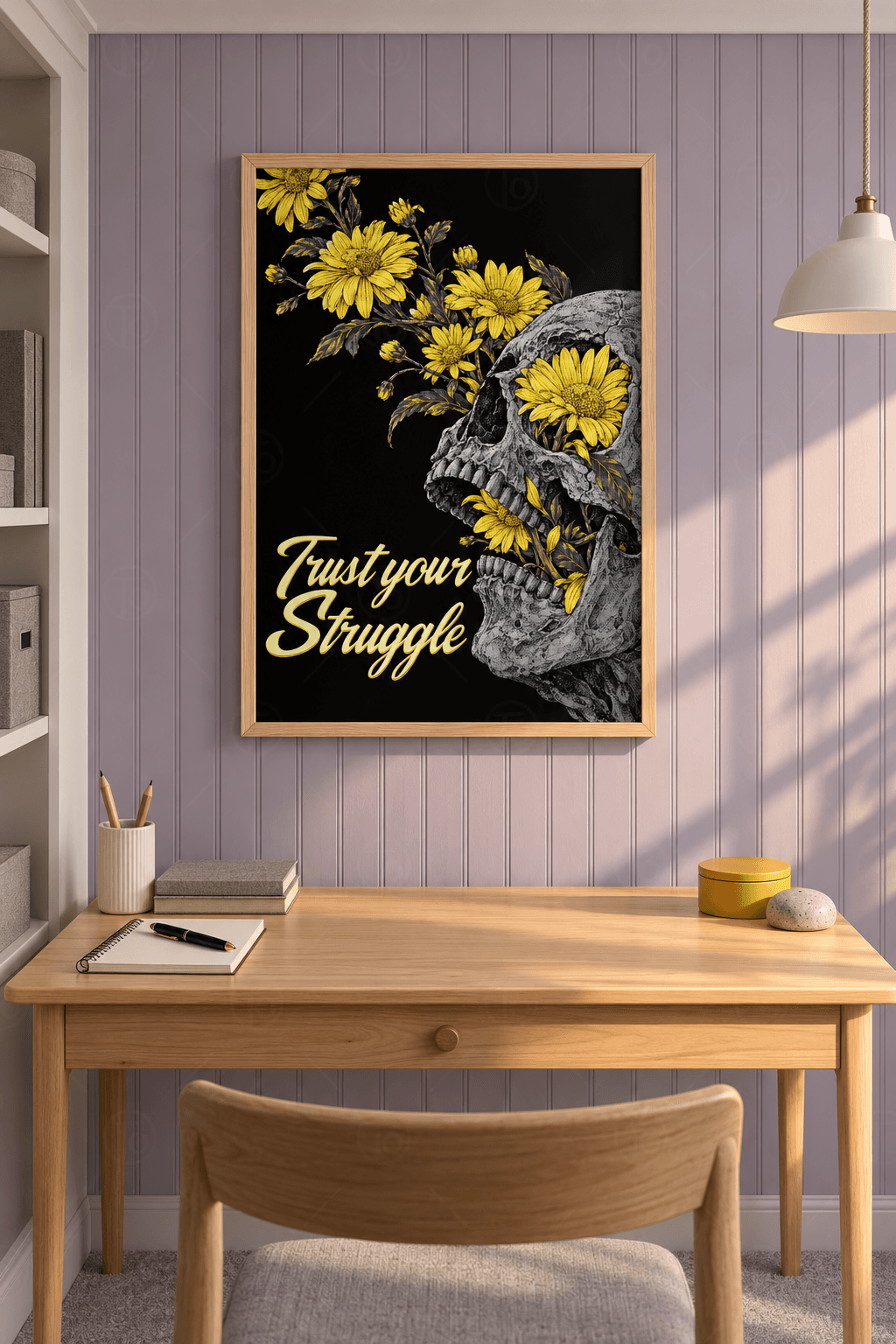 Ahşap çerçeveli motivasyon tablosu — siyah zeminde sarı çiçekler fışkıran gri kafatası ve Trust your Struggle yazısı
