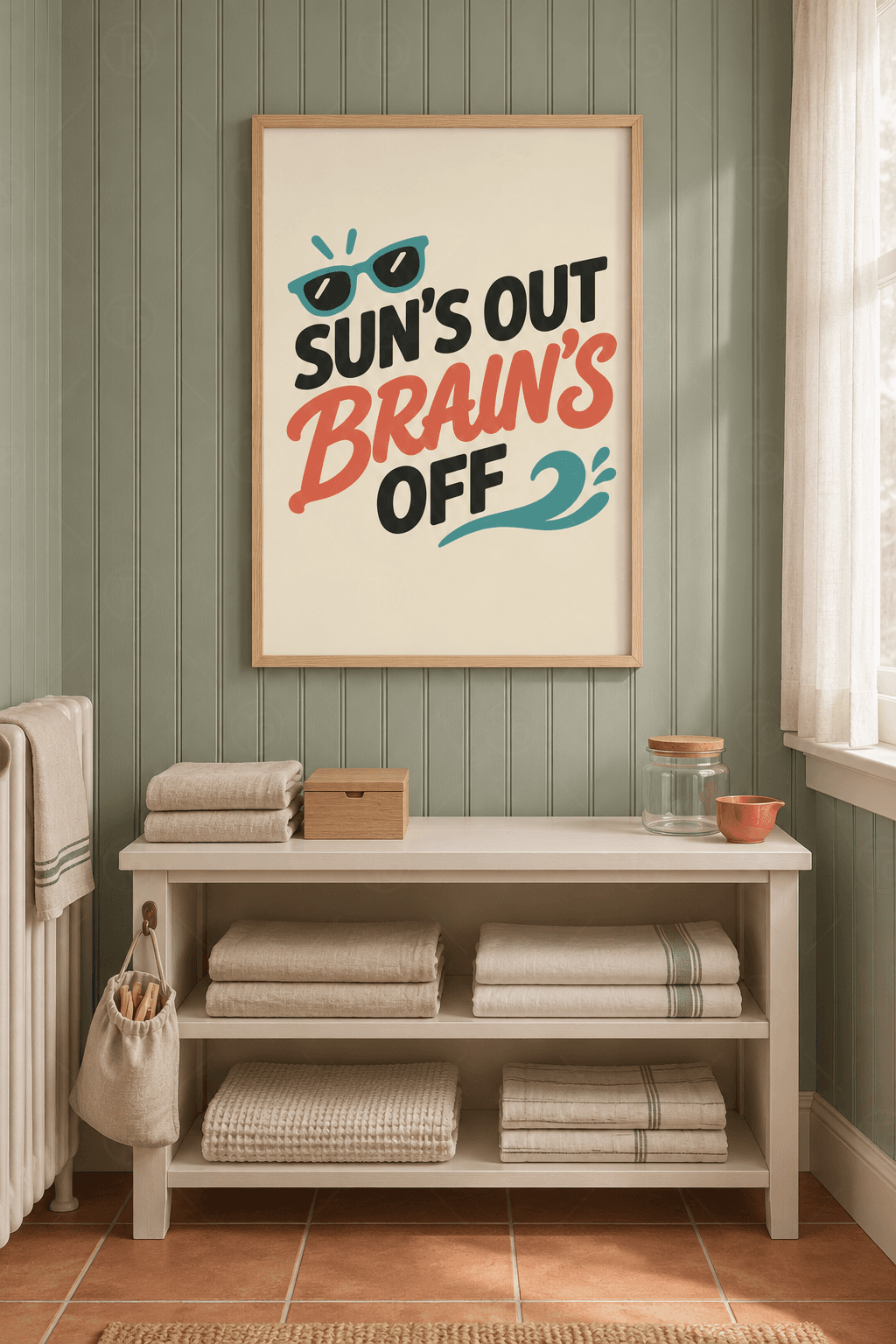 Ahşap çerçeveli tipografik tablo — krem zeminde siyah ve mercan Sun's Out Brain's Off yazısı, turkuaz gözlük ve dalga